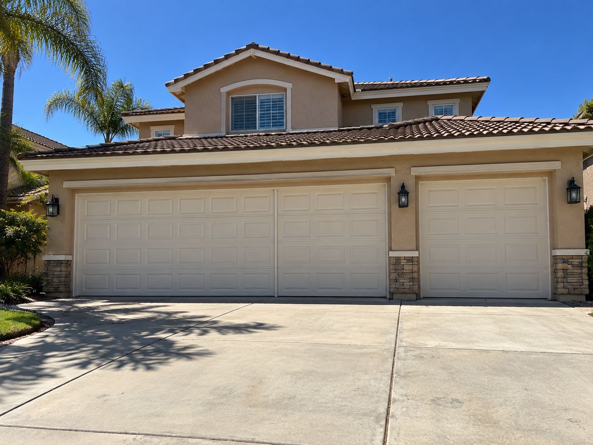 Two-story home with a white double garage door and a separate single garage door beside it