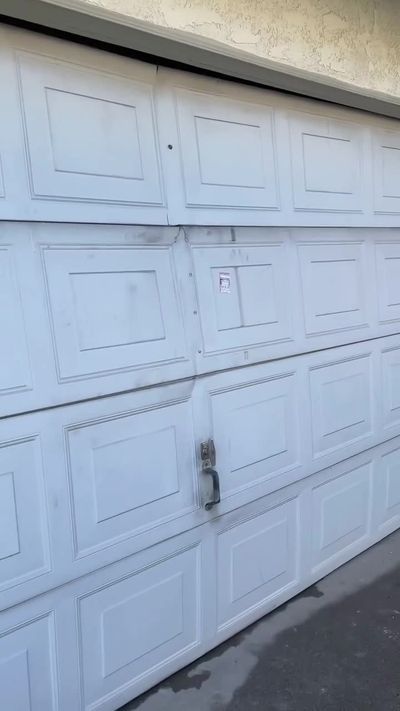 White raised-panel double garage door in Anaheim, running again after a major internal repair