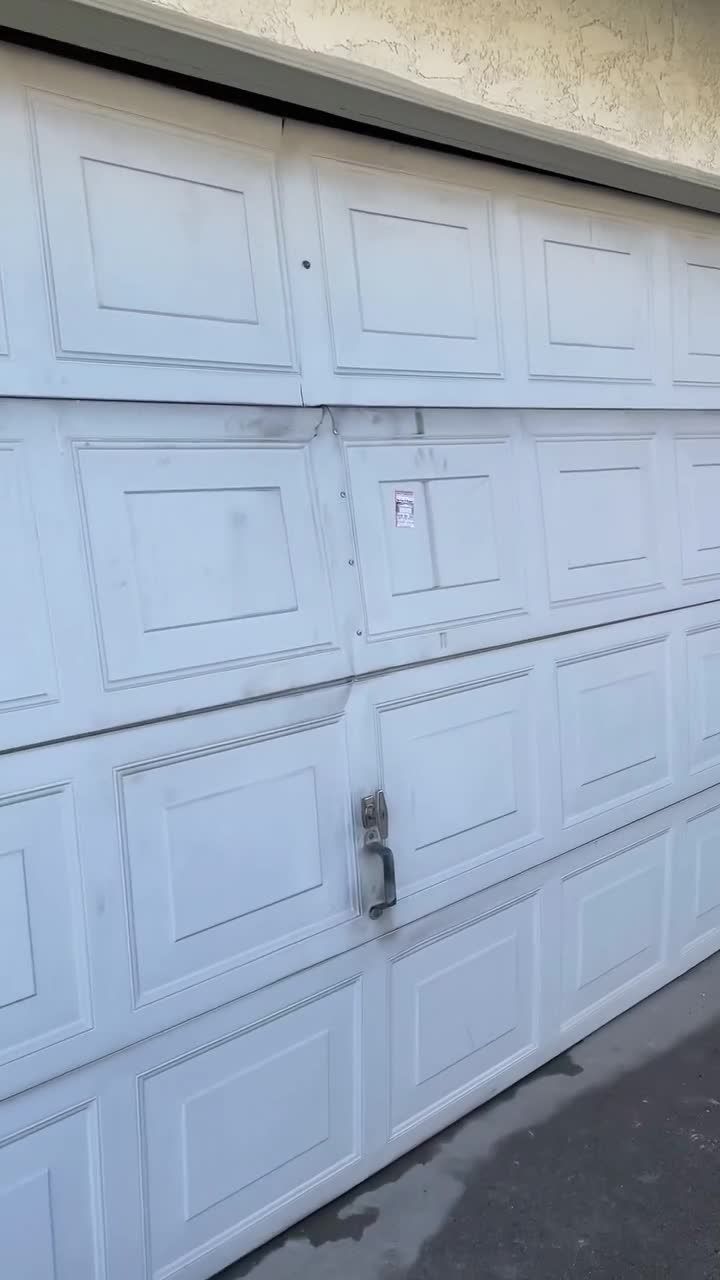 White raised-panel double garage door in Anaheim, running again after a major internal repair