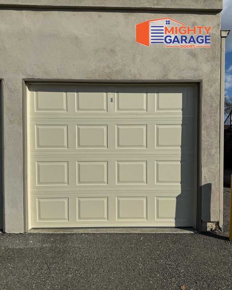 Almond raised-panel single garage door set in a stucco wall in Riverside